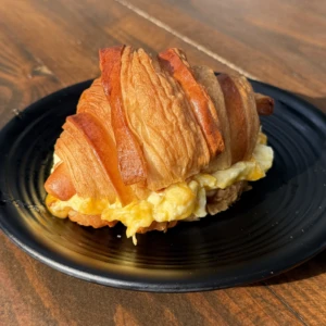 Flaky breakfast croissant sandwich with eggs and melted cheese served at The Coffee Garden in the Heights, Houston TX 77007.