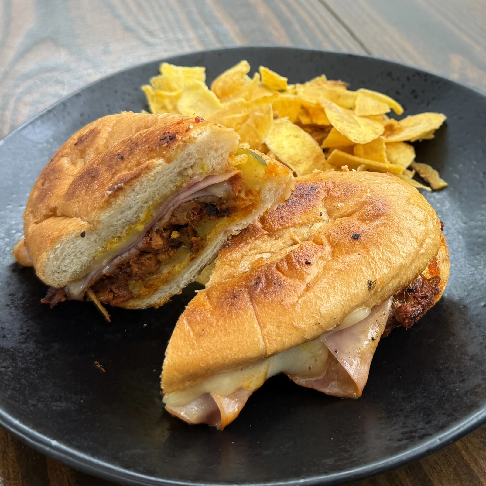 Cubano sandwich with achiote carnitas, ham, Swiss cheese, pickles, and plantain chips at The Coffee Garden in the Heights, Houston TX 77007.