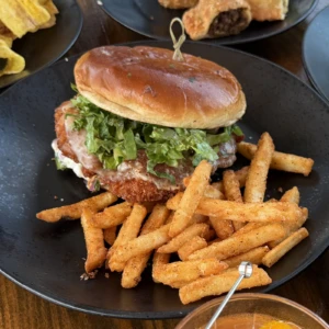 Latino Chicken Sandwich with plantain-crusted chicken, provolone cheese, lettuce, and fries at The Coffee Garden in the Heights, Houston TX 77007.